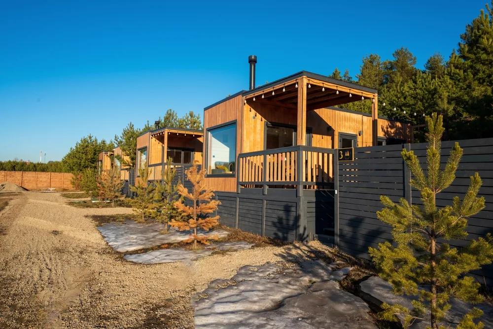 A,Wooden,Cabin,With,A,Small,Tree,In,The,Foreground